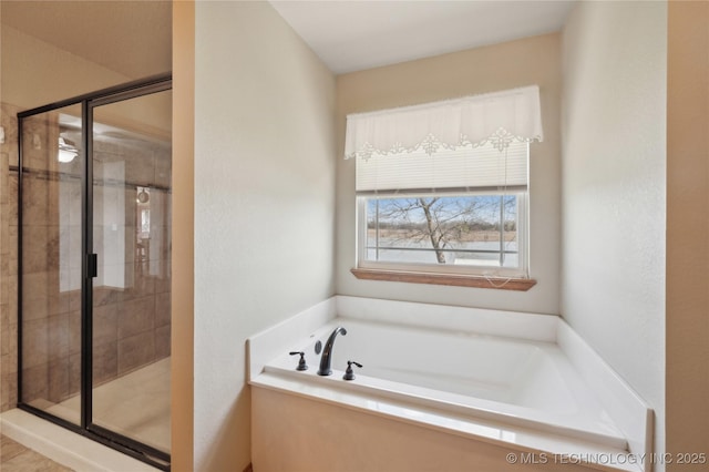 bathroom featuring a garden tub and a shower stall