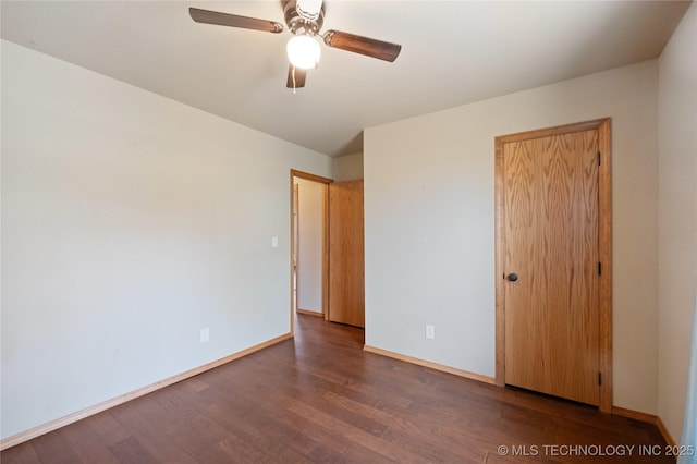 unfurnished bedroom with baseboards, wood finished floors, a closet, and a ceiling fan