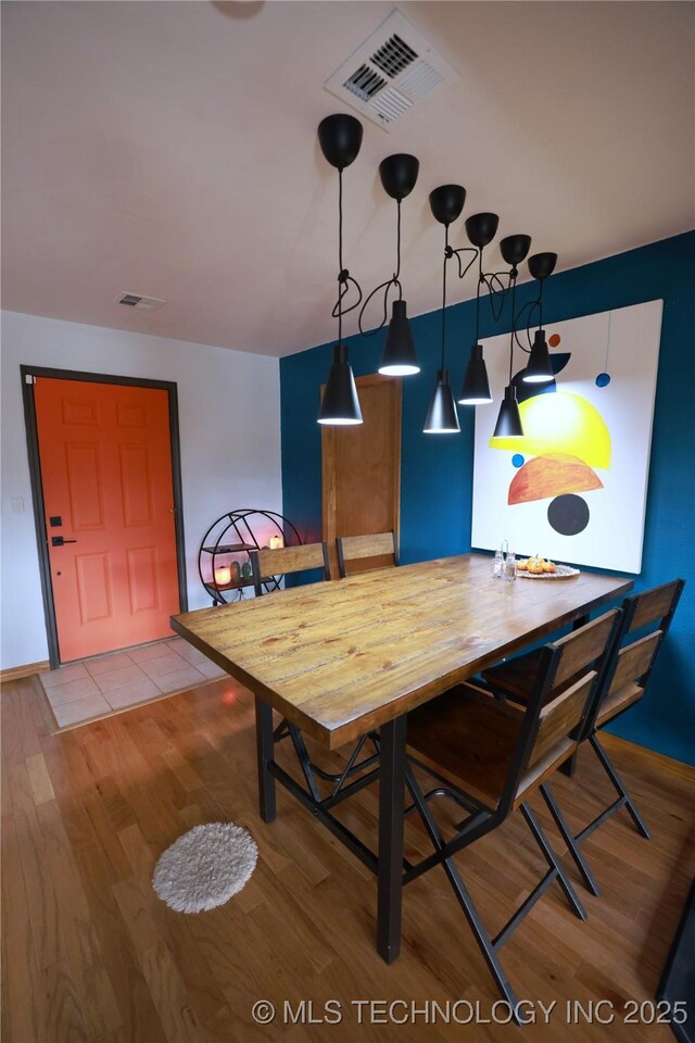 dining space featuring visible vents and wood finished floors