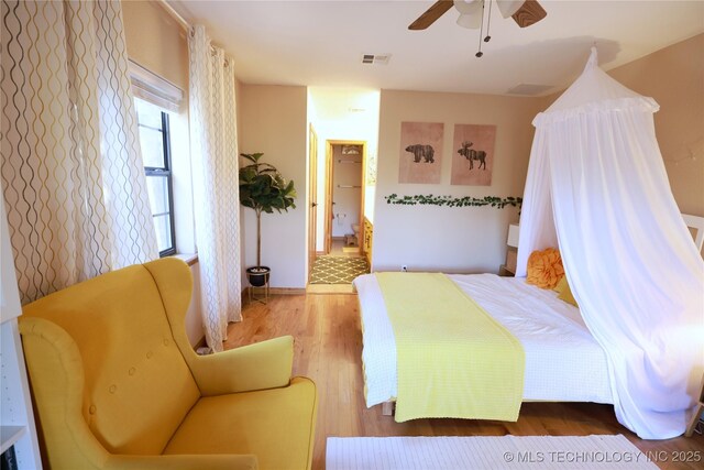 bedroom with visible vents, a ceiling fan, and wood finished floors