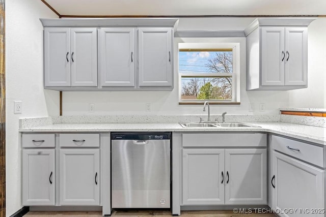 kitchen featuring light stone countertops, a sink, and dishwasher
