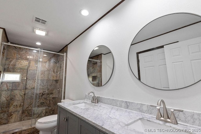 full bathroom featuring toilet, a sink, a shower stall, and visible vents