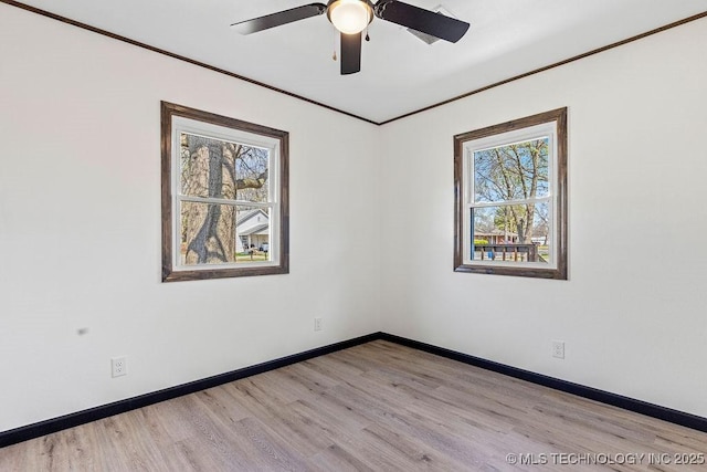 empty room with baseboards, a wealth of natural light, ceiling fan, and ornamental molding