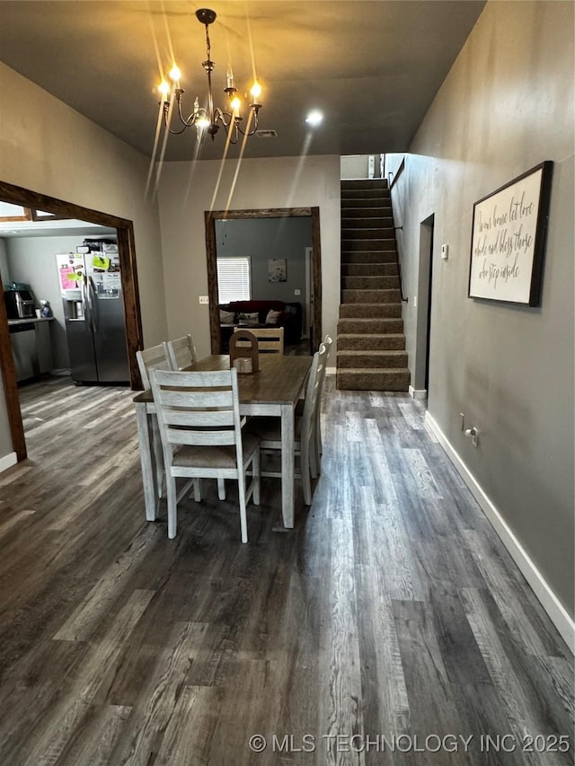 dining room with stairs, baseboards, a notable chandelier, and dark wood-style floors
