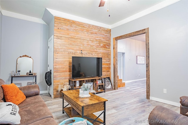 living area with ceiling fan, baseboards, and light wood finished floors