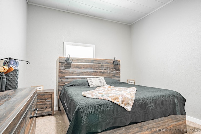 bedroom with baseboards, crown molding, and speckled floor