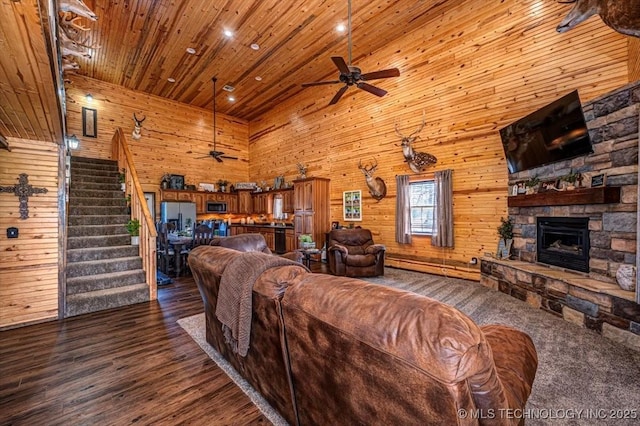 living room featuring wooden ceiling, stairway, a high ceiling, dark wood-style floors, and ceiling fan