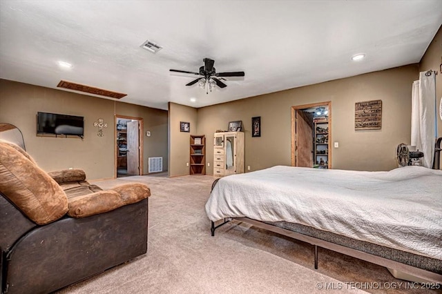 carpeted bedroom featuring ceiling fan, visible vents, and attic access