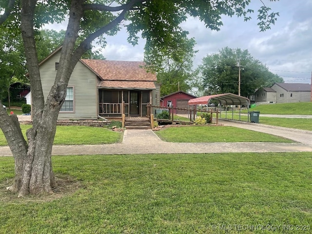 bungalow-style home with a detached carport, a shingled roof, and a front lawn