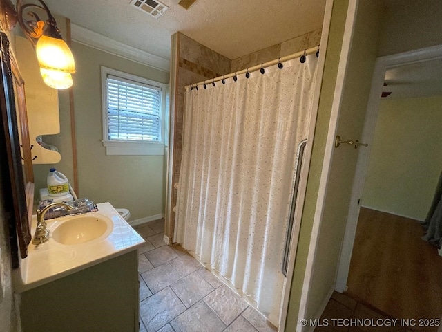 bathroom featuring visible vents, curtained shower, vanity, ornamental molding, and stone tile floors