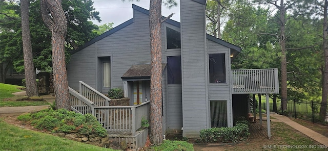 7502 S Winston Pl Unit 203, Tulsa, OK 74136 - view of property exterior featuring stairway, a deck, and a chimney