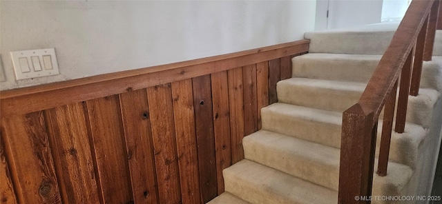 7502 S Winston Pl Unit 203, Tulsa, OK 74136 - staircase with wainscoting and wood walls