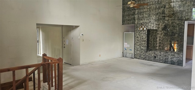 7502 S Winston Pl Unit 203, Tulsa, OK 74136 - unfurnished living room with unfinished concrete flooring, ceiling fan, and a high ceiling