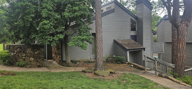 7502 S Winston Pl Unit 203, Tulsa, OK 74136 - view of home's exterior with a chimney and a yard