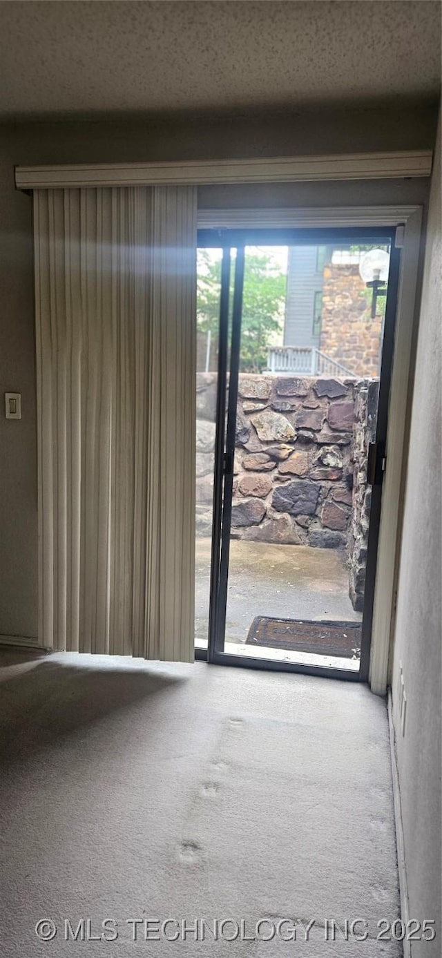 7502 S Winston Pl Unit 203, Tulsa, OK 74136 - doorway to outside featuring carpet