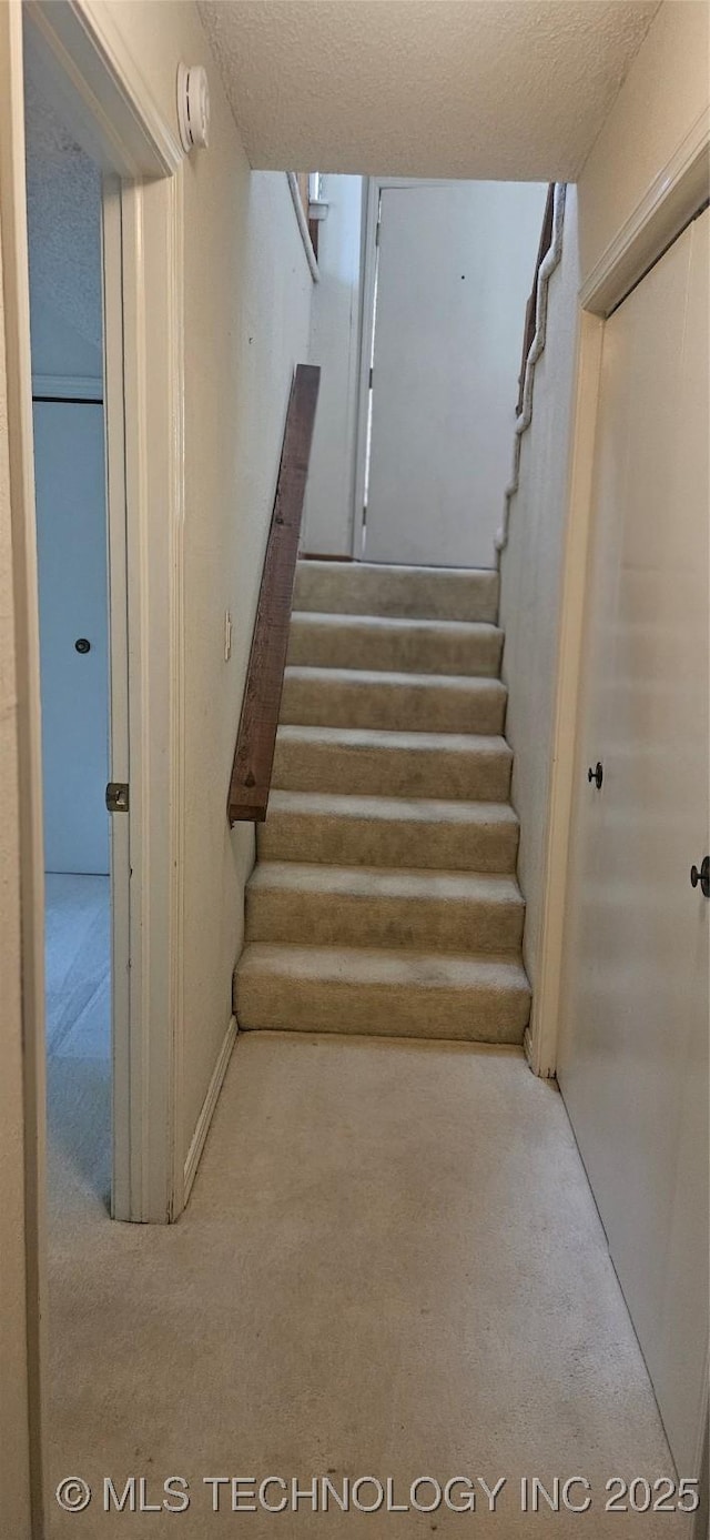 7502 S Winston Pl Unit 203, Tulsa, OK 74136 - stairs featuring carpet flooring and a textured ceiling