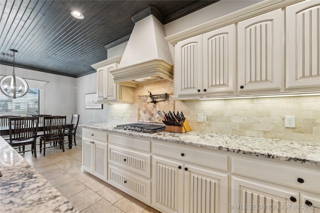 19672 E 69th St N, Owasso, OK 74055 - kitchen featuring cream cabinetry, custom exhaust hood, stainless steel gas stovetop, a chandelier, and backsplash