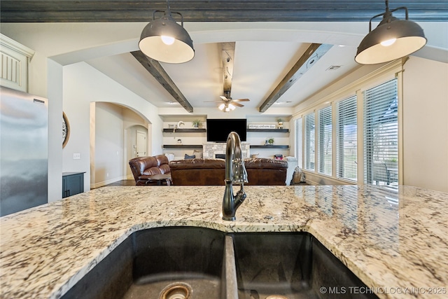 19672 E 69th St N, Owasso, OK 74055 - kitchen featuring stainless steel fridge, light stone countertops, ceiling fan, a sink, and beam ceiling