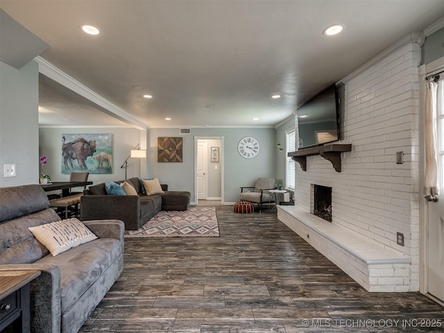 living area with wood finished floors, crown molding, a fireplace, and recessed lighting
