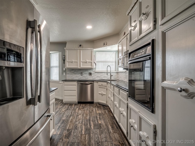 kitchen with decorative backsplash, a sink, stainless steel appliances, and plenty of natural light