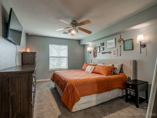 bedroom with a textured ceiling, baseboards, visible vents, ceiling fan, and carpet