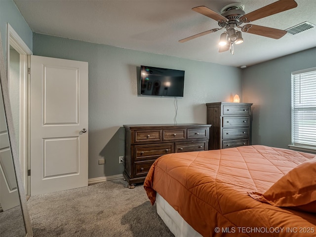 carpeted bedroom with baseboards, visible vents, and ceiling fan