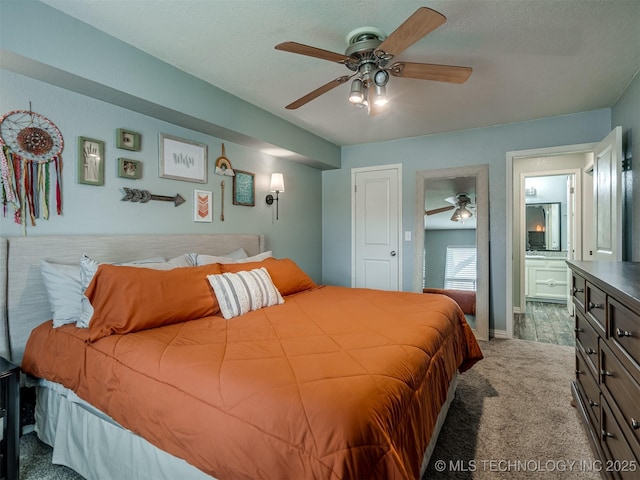 carpeted bedroom with a ceiling fan, ensuite bathroom, and a textured ceiling