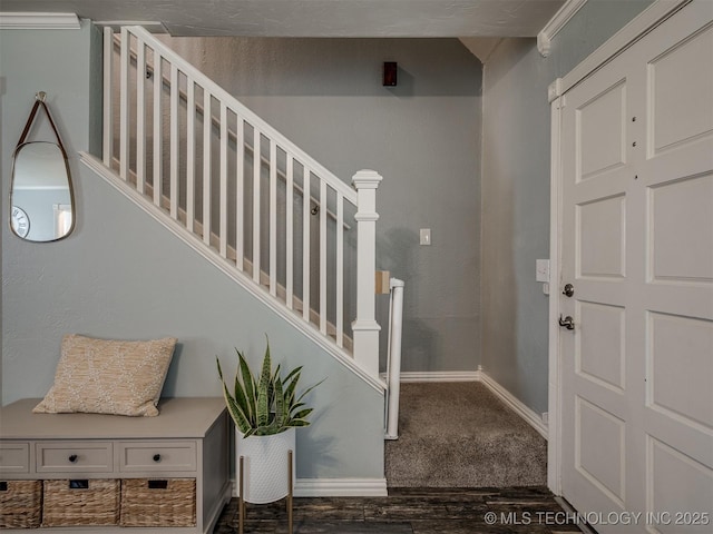 carpeted entryway with baseboards and stairs