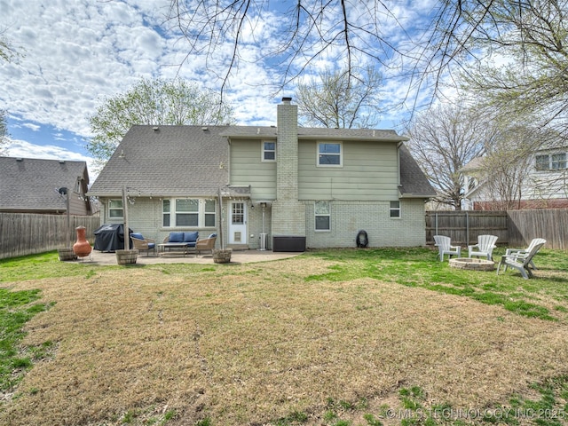 rear view of property with a patio, a fire pit, a fenced backyard, and a yard