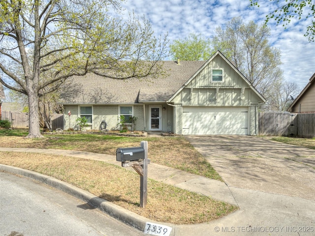 view of front of property featuring driveway, a shingled roof, fence, and brick siding