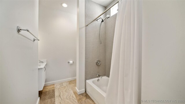 full bath featuring shower / bath combo and baseboards