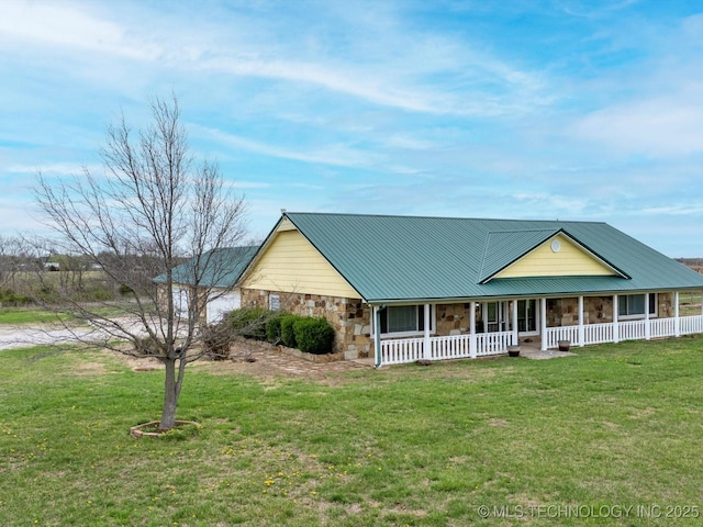 view of front of house featuring a front lawn, metal roof, a porch, and stone siding