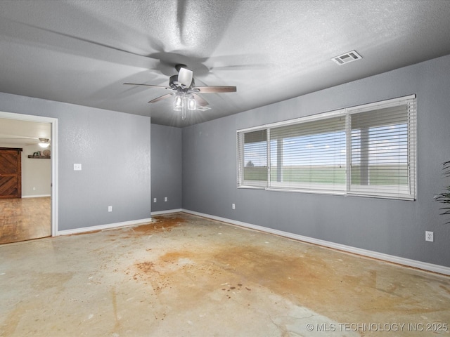 empty room with concrete flooring, a textured ceiling, visible vents, and a ceiling fan