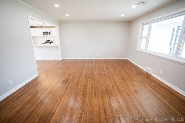 5760 E 29th St, Tulsa, OK 74114 - unfurnished room featuring baseboards, ornamental molding, visible vents, and wood finished floors