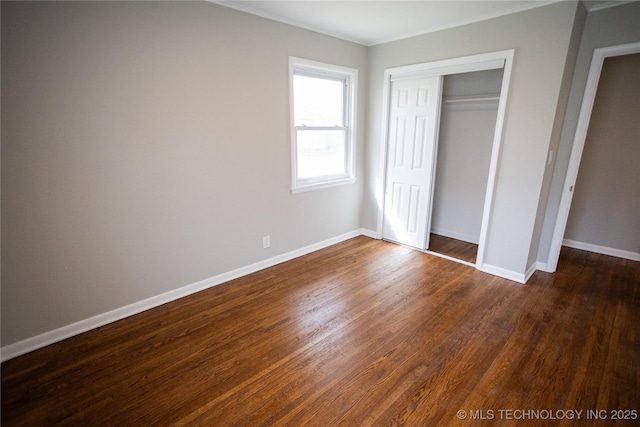 5760 E 29th St, Tulsa, OK 74114 - unfurnished bedroom featuring baseboards, dark wood-style flooring, and a closet