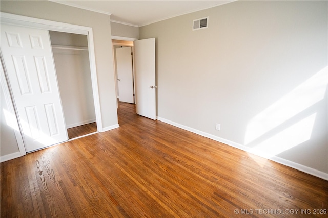 5760 E 29th St, Tulsa, OK 74114 - unfurnished bedroom featuring a closet, visible vents, baseboards, ornamental molding, and wood finished floors