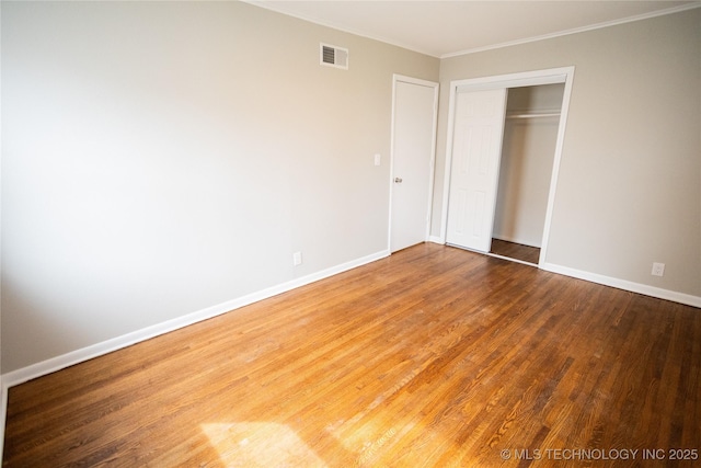 5760 E 29th St, Tulsa, OK 74114 - unfurnished bedroom featuring baseboards, visible vents, a closet, and wood finished floors