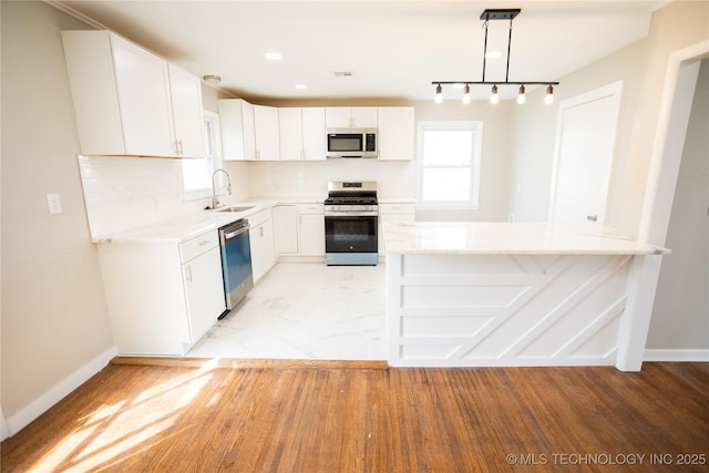5760 E 29th St, Tulsa, OK 74114 - kitchen with white cabinetry, a sink, appliances with stainless steel finishes, and backsplash