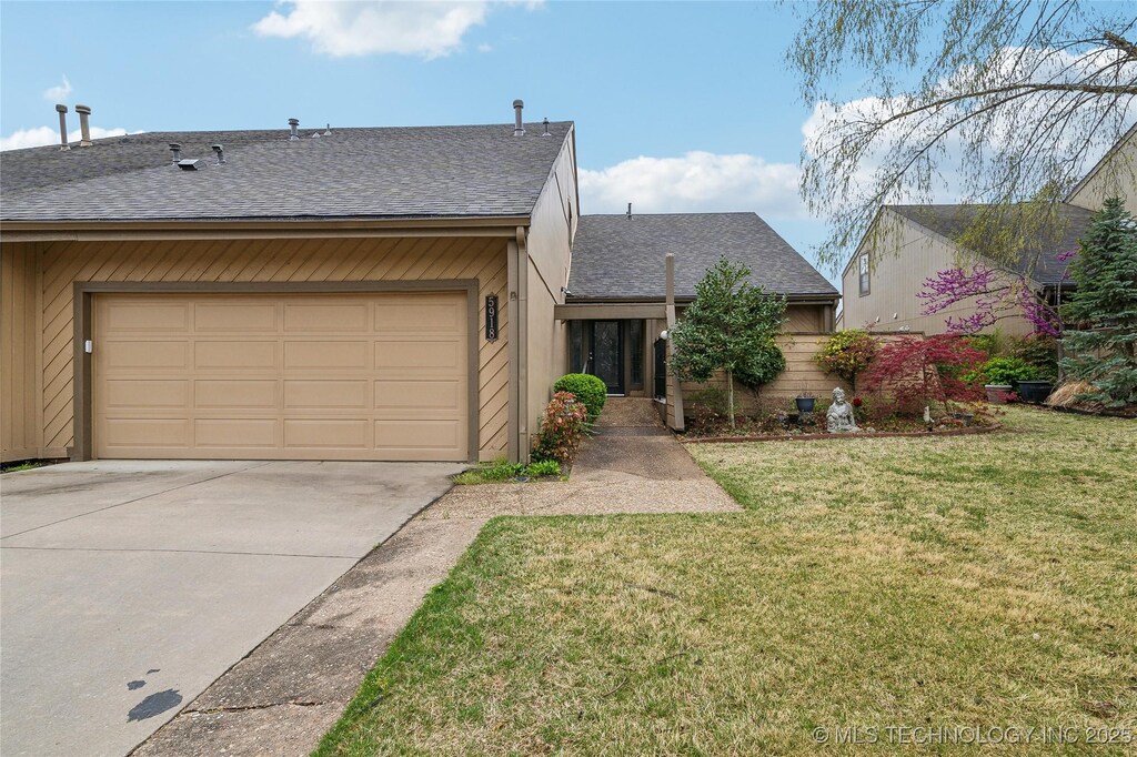 5918 S Atlanta Pl Unit 2, Tulsa, OK 74105 - view of front of house with a front yard, driveway, a garage, and roof with shingles