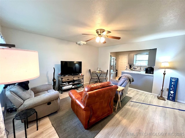 429937 E 1159th Rd, Porum, OK 74455 - living area featuring light wood-style flooring, ceiling fan, and a textured ceiling