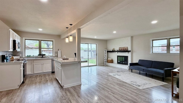 1721 S 114th E Ave, Tulsa, OK 74128 - kitchen featuring open floor plan, white cabinets, light wood-style flooring, and appliances with stainless steel finishes