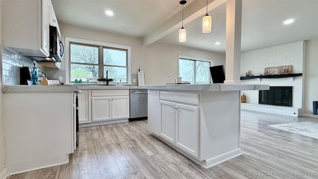 1721 S 114th E Ave, Tulsa, OK 74128 - kitchen featuring light countertops, light wood finished floors, white cabinetry, appliances with stainless steel finishes, and beamed ceiling