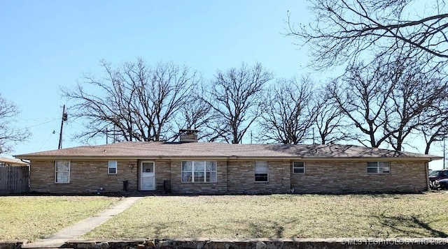 ranch-style house featuring a front lawn, a chimney, and stone siding
