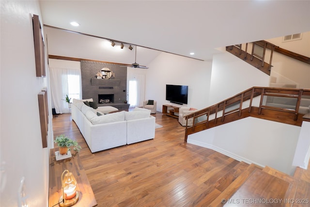 living room with a fireplace, stairway, wood finished floors, a ceiling fan, and recessed lighting