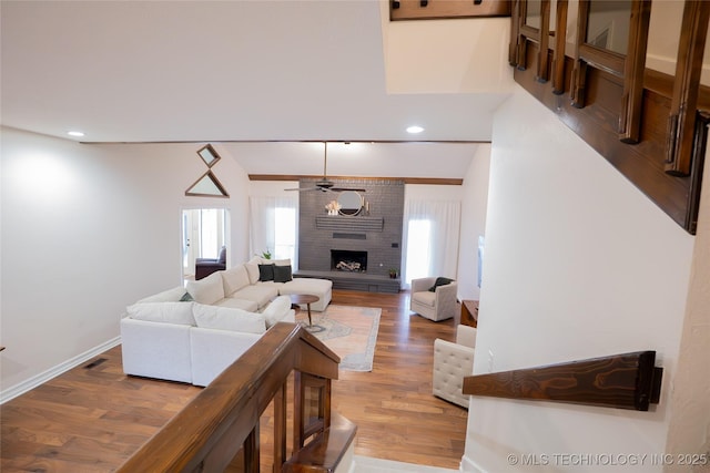 living room featuring a fireplace, light wood finished floors, ceiling fan, baseboards, and recessed lighting