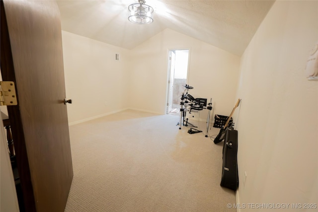 exercise room with vaulted ceiling, carpet flooring, and baseboards