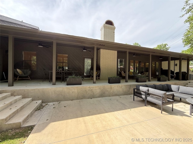 back of house featuring a ceiling fan, an outdoor living space, a patio area, outdoor dining space, and a chimney