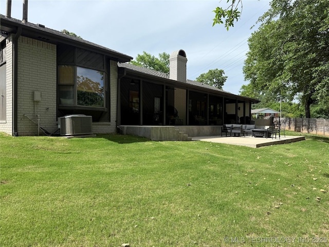 back of house featuring outdoor lounge area, cooling unit, a chimney, a patio area, and brick siding
