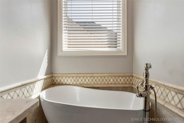 3528 S Wheeling Ave, Tulsa, OK 74105 - bathroom featuring a freestanding tub and a wainscoted wall