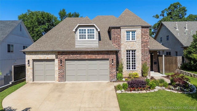 3528 S Wheeling Ave, Tulsa, OK 74105 - view of front facade featuring a shingled roof, concrete driveway, stone siding, brick siding, and an attached garage
